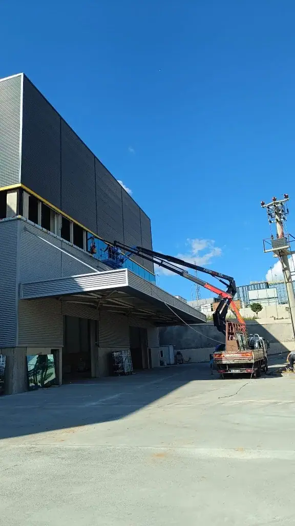 Endüstriyel bir yapının üst kotundaki cam bant için vinçli montaj