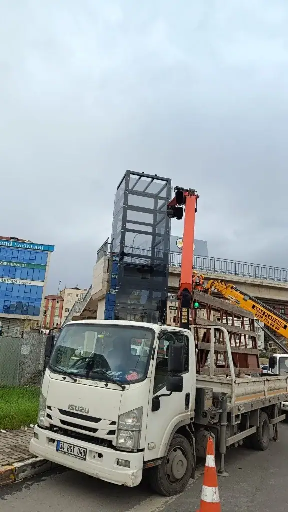 Yüksek kotta cam kaplı bir yapıya vinçli araçla cam taşınması